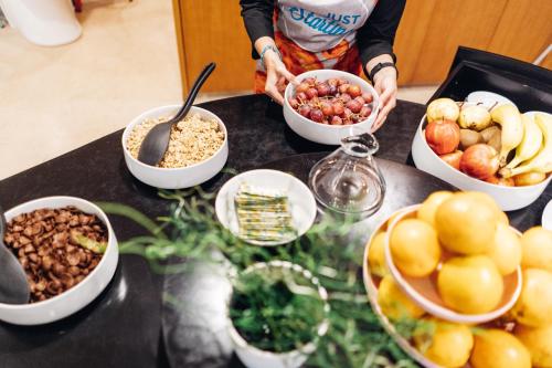 a person preparing food on a counter with bowls of food at Stay Hotel Guimarães Centro in Guimarães