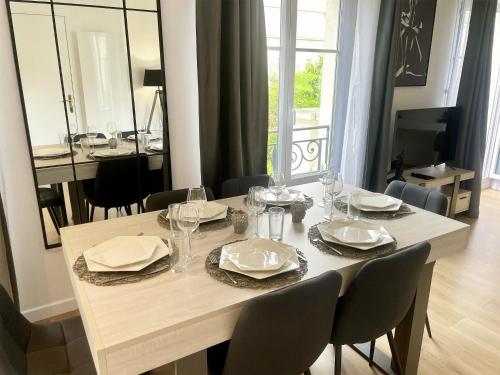 une table de salle à manger avec des assiettes et des verres dessus dans l'établissement Val d'Europe By Plaza - Proche Disneyland, à Serris