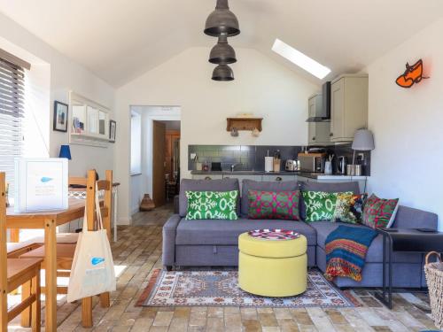 a living room with a blue couch and a kitchen at The Grain Store in Norwich