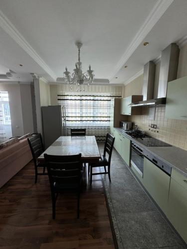 a large kitchen with a table and chairs in it at Трехкомнатная просторная квартира 137 кв центре возле ТЦ Infinity Mall in Atyraū