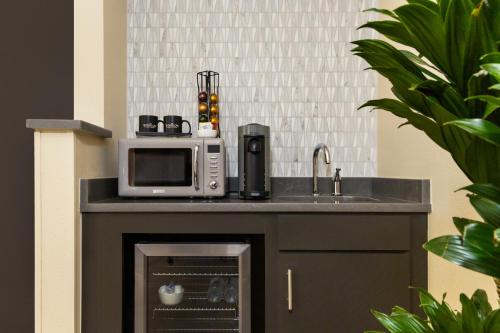 a kitchen with a microwave and a sink at The Winslow - Oklahoma City in Oklahoma City