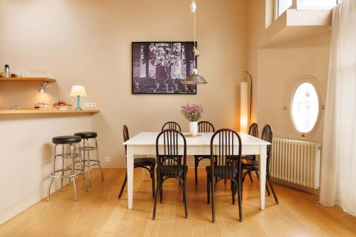 une salle à manger avec une table et des chaises blanches dans l'établissement Charmante maison - Boulogne, à Boulogne-Billancourt