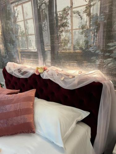 a bed with a red head board with flowers on it at Ca' Barbieri San Donà in San Donà di Piave