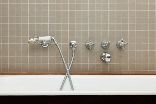 La salle de bains est pourvue d'une douche et d'une baignoire blanche. dans l'établissement Charmante maison - Boulogne, à Boulogne-Billancourt