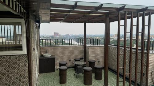 a balcony with stools and a table on a building at Riverfront Penthouse Studio with Spacious Terrace in Lucknow