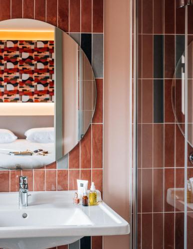 a bathroom with a sink and a mirror at La Maison Rabelais in Amboise