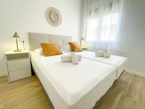 a large white bed in a room with a window at Apartamentos Zaragoza Gran Vía 3000 in Zaragoza
