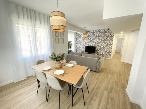 a dining room and living room with a table and chairs at Apartamentos Zaragoza Gran Vía 3000 in Zaragoza