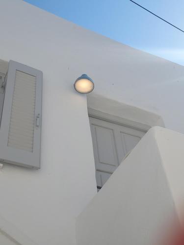 a white room with a light on the wall at Holy Summer in Naousa Market Streets in Naousa