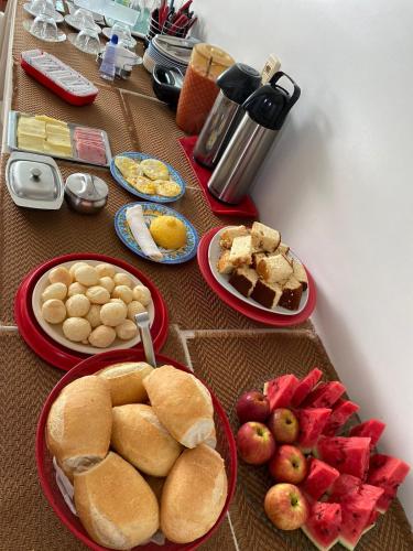 einen Tisch mit Teller mit Lebensmitteln und Obst in der Unterkunft Hotel Cajuapara 2 in Acailandia