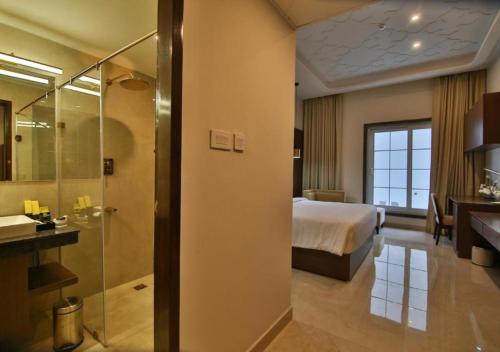 a hotel room with a bed and a bathroom at Accord Chrome in Chennai