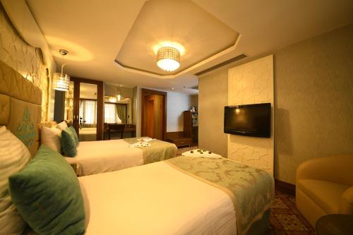 a hotel room with two beds and a television at Grand Star Hotel Premium in Istanbul