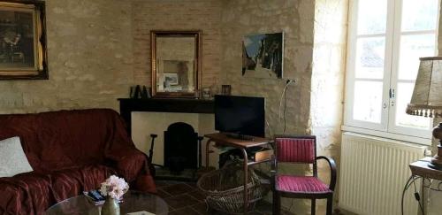 un salon avec un canapé et une cheminée dans l'établissement Gîte la Muzardie, à Campagne