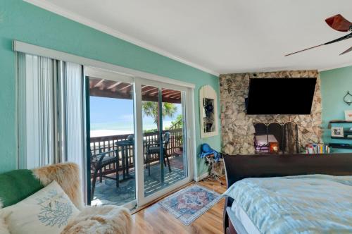 a bedroom with a bed and a balcony with a television at Walk to North Beach in Clearwater Beach
