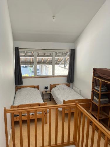 deux lits dans une chambre avec une fenêtre dans l'établissement Le Prieure Valette, à Hérouville-Saint-Clair