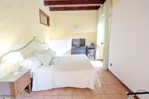 a bedroom with a bed and a table and a kitchen at Veronetta House in Verona
