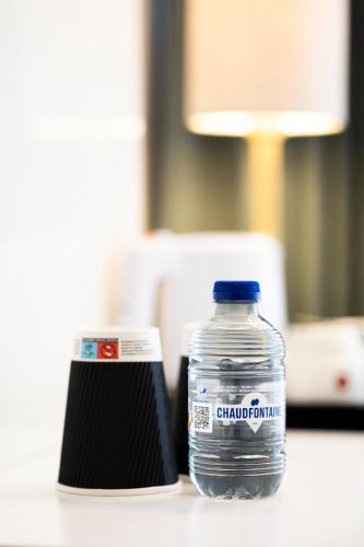 a bottle of water and a can on a table at Hotel Louise in Brussels