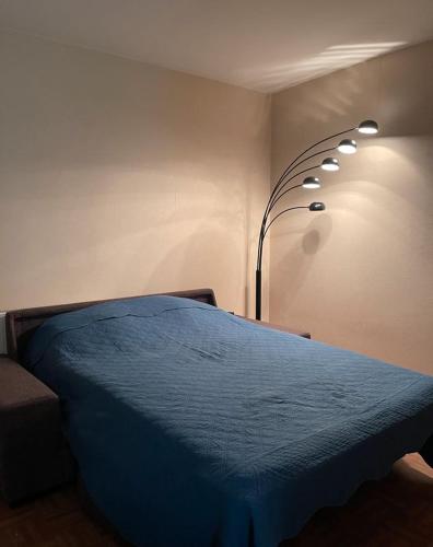 - une chambre avec un lit bleu et une lampe dans l'établissement Location saisonnière Argenteuil, à Argenteuil