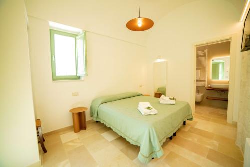 a bedroom with a green bed and a sink at Coppola di Seta in Locorotondo
