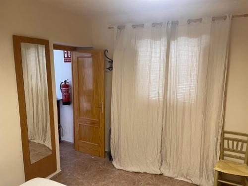 a room with a door and a window with curtains at Casa Juana Cehegín in Cehegín