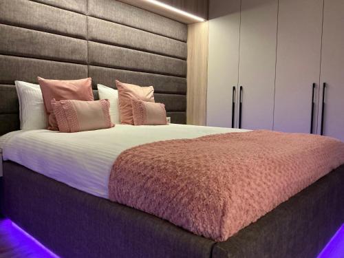 a bedroom with a large bed with pink pillows at PlatinumHomes42 in Plovdiv