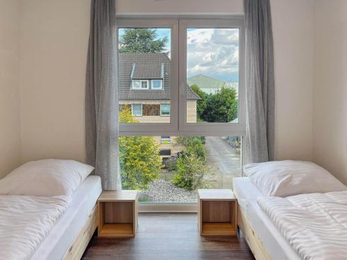 two beds in a room with a large window at T&K Apartments - Mettmann - Schöne 5 Zimmer Maisonette - 20min Messe Fair DUS in Mettmann