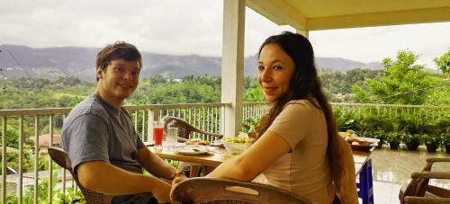 a man and a woman sitting at a table on a porch at Pretty Villa in Gelioya