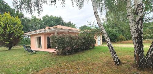 une petite maison avec un banc dans une cour dans l'établissement La Villa des Pins Confort pour 6 personnes, à Andernos-les-Bains
