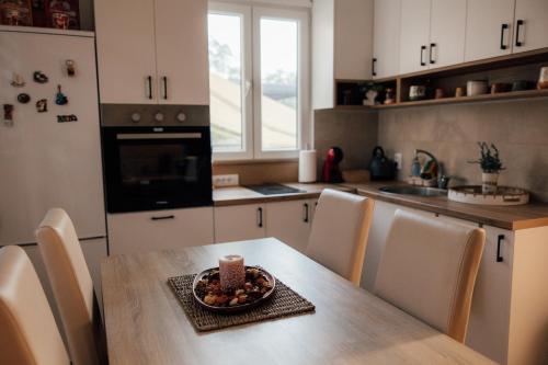 a kitchen with a table with a bowl of fruit on it at Šapat Vetra vikendica in Vršac