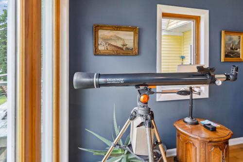 a telescope in a room with a blue wall at Sunset Haven - Lakeside Retreat in GOTL in Geneva
