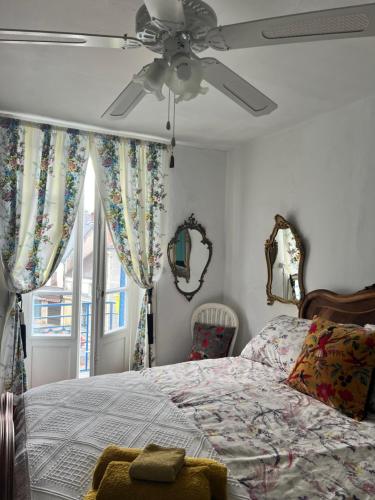 une chambre avec un lit et un ventilateur de plafond dans l'établissement Original and quirky village home, à Giat