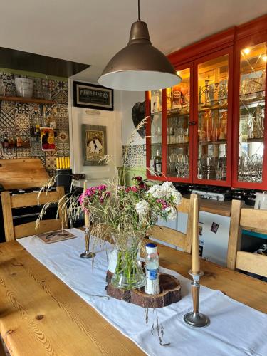 une table avec un vase de fleurs dessus dans l'établissement Original and quirky village home, à Giat