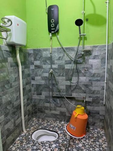 a bathroom with a toilet and a phone on the wall at Mohan Homestay in Kuala Terengganu