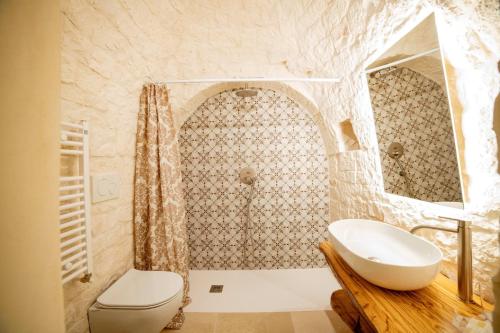 a bathroom with a white sink and a toilet at Coppola di Seta in Locorotondo