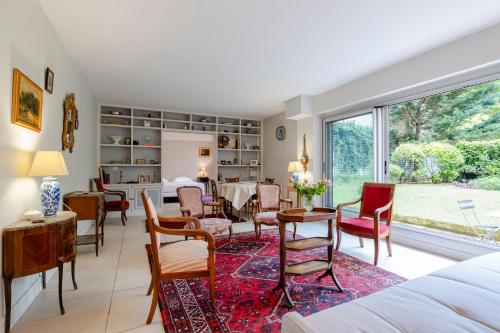 un salon avec une table et des chaises dans l'établissement Veeve - The Garden of La Muette, à Paris
