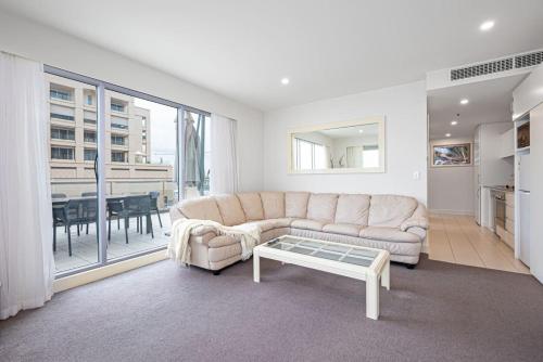 a living room with a couch and a table at Beachfront Serenity Glenelg in Glenelg