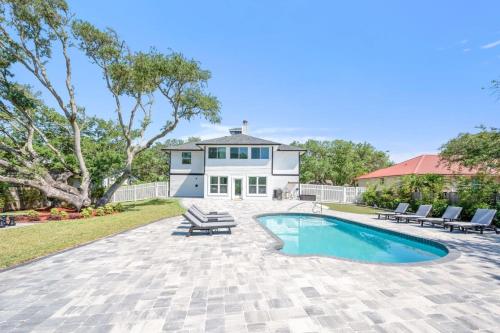 a home with a swimming pool and a house at Vilano Rose Slps 24, 6Bds, 5 Bths, Pool, Wlk to Beach, Golf, Pets in Saint Augustine