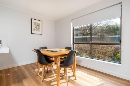 a dining room with a table and chairs and a large window at Apt in Kingston - 10min to Lake Burley Griffin - Hosted by Canstay in Kingston 