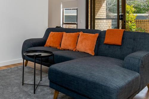 a blue couch with orange pillows in a living room at Apt in Kingston - 10min to Lake Burley Griffin - Hosted by Canstay in Kingston 