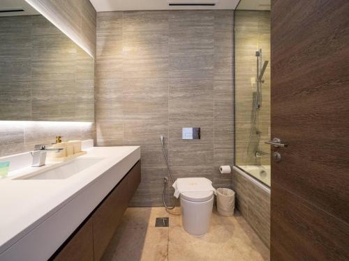 a bathroom with a sink and a toilet and a shower at Cosy Modern Waterfront Studio in Maritime City in Dubai