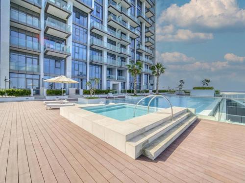 a swimming pool in front of a building at Cosy Modern Waterfront Studio in Maritime City in Dubai