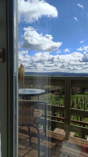 a view from a balcony with a table and a chair at NemCsuri Vendegház Somló in Somlóvásárhely