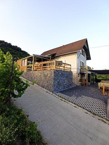 a house with a stone wall next to a building at NemCsuri Vendegház Somló in Somlóvásárhely