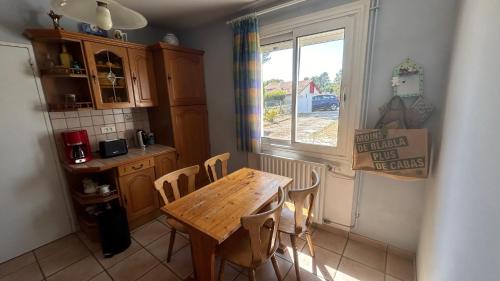 une cuisine avec une table en bois et une fenêtre dans l'établissement La Pampa, à Mimizan