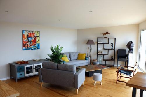 un salon avec un canapé et une table dans l'établissement L'escale, à Bretteville-sur-Ay