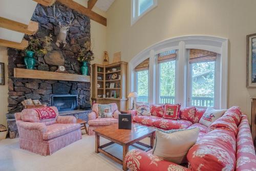 a living room with a red couch and a stone fireplace at Lodge Apartment II Condo 886 in Sun Valley