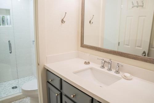 Un baño con lavabo, inodoro y espejo. en Ranch Condo 3538, en Elkhorn Village