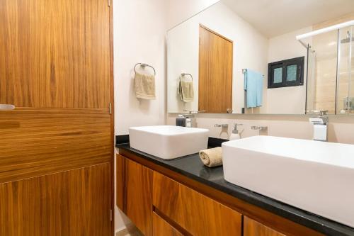 a bathroom with two sinks and a large mirror at Departamento amplio con balcon y mini alberca privada in Tulum