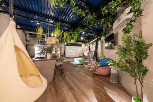 a room with potted plants on the walls and a counter at 西九条駅徒歩3分 無料Netflix サウナ ハンモック プロジェクター 寝室5つ トイレお風呂3台 in Osaka