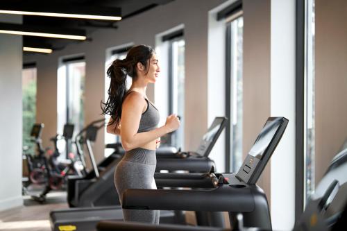 a woman running on a treadmill in a gym at Loews Nashville Hotel at Vanderbilt Plaza in Nashville